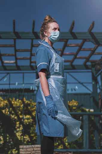 A medical assistant wearing PPE stood outside.